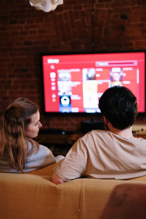 couple détendu regardant la télévision à la maison Smart X2