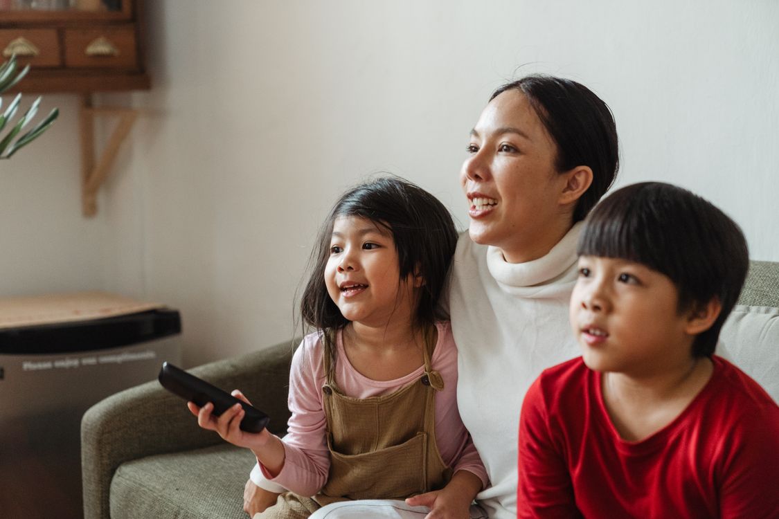 famille noire regardant la télévision ensemble sur le canapé
