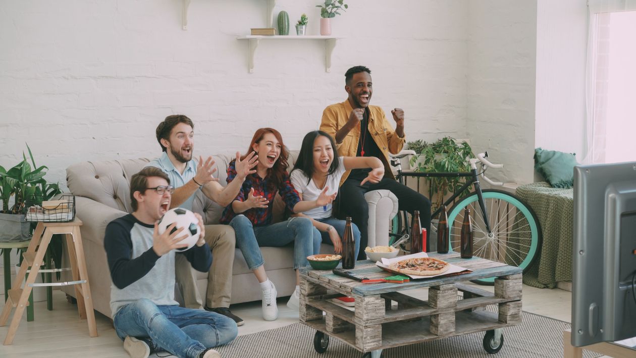 groupe d'amis euphoriques regardant le match de football à la télévision